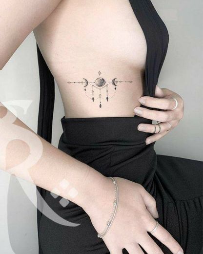Tatuagem feminina de planeta para costela
