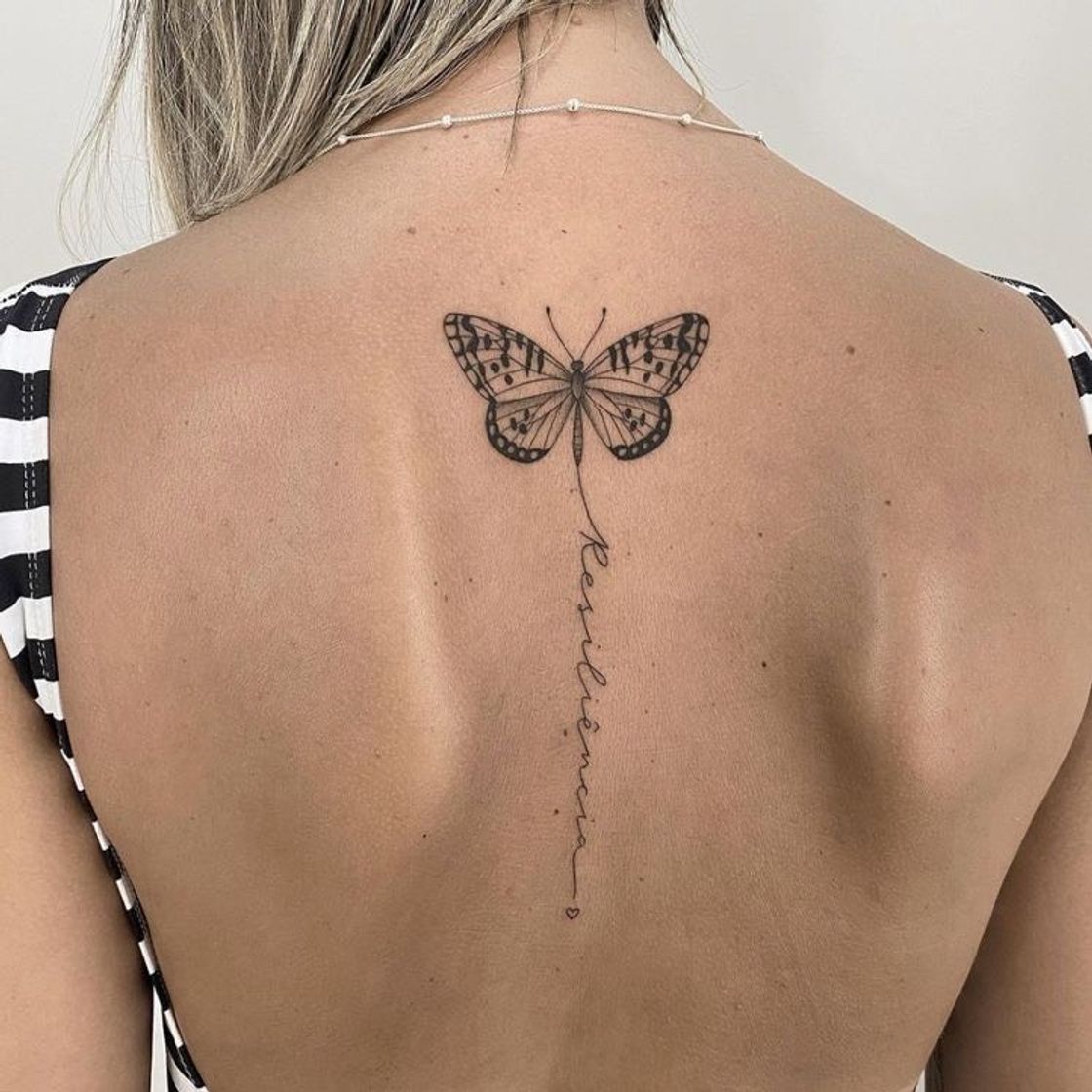 Social Tatuagem de borboleta nas costas com frase.
