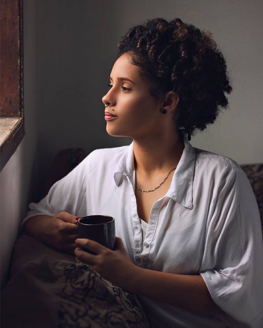 Olhar direto para uma fonte de luz, segurando uma caneca 