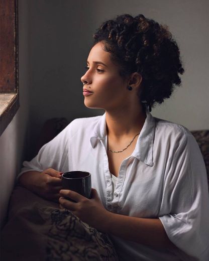 Olhar direto para uma fonte de luz, segurando uma caneca 