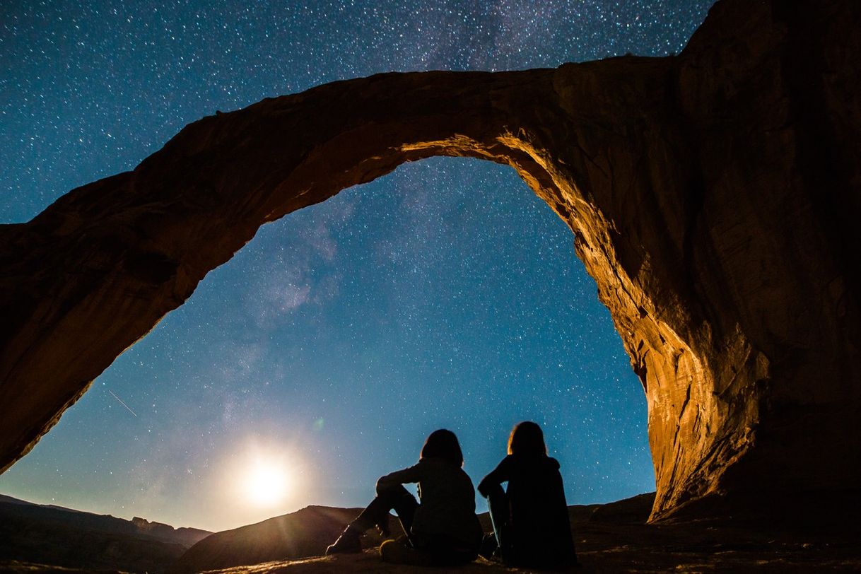 Moda two person sitting under rock monolith photo – Free Image - Unsplash